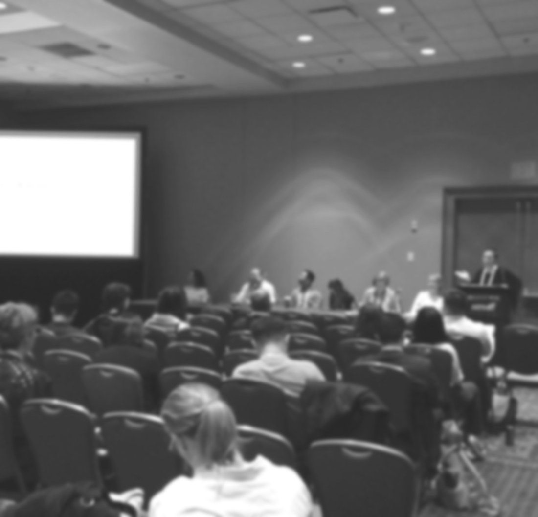 A softened black-and-white view of a conference panel session on AI in education